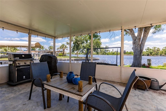 sunroom featuring a water view