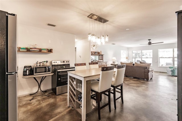9656 SW Marina Dr, Arcadia, FL 34269 - kitchen with appliances with stainless steel finishes, concrete flooring, a kitchen bar, a center island, and open shelves