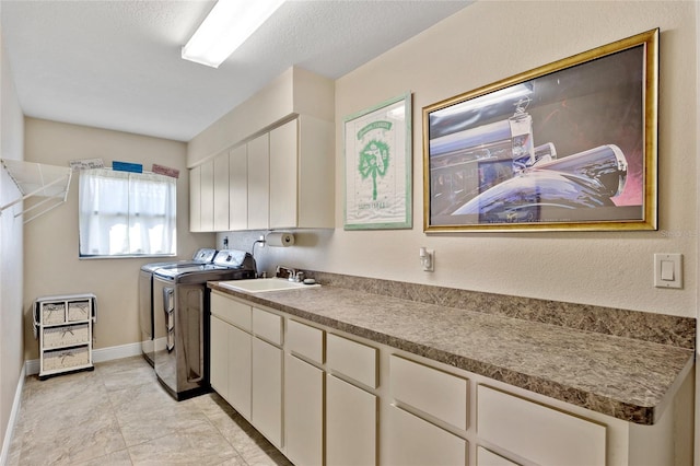 laundry area with cabinets, sink, a textured ceiling, and independent washer and dryer