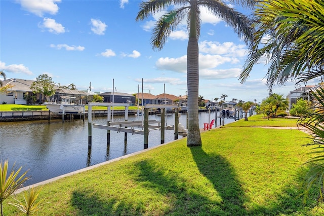 view of dock with a lawn and a water view