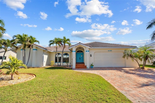 mediterranean / spanish-style house with a garage and a front yard