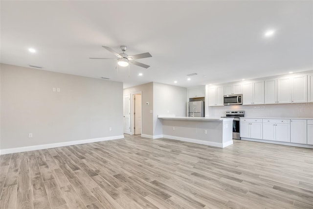 unfurnished living room featuring ceiling fan and light wood-type flooring