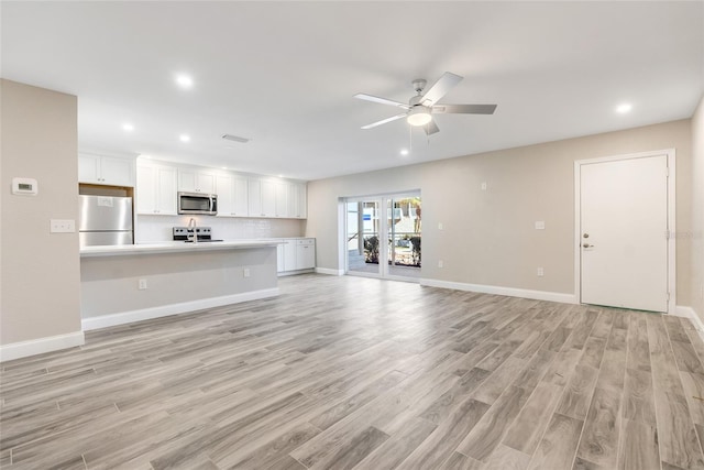 unfurnished living room with ceiling fan and light hardwood / wood-style floors