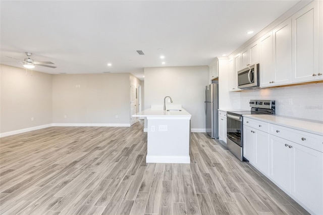 kitchen with white cabinetry, sink, stainless steel appliances, and light hardwood / wood-style floors