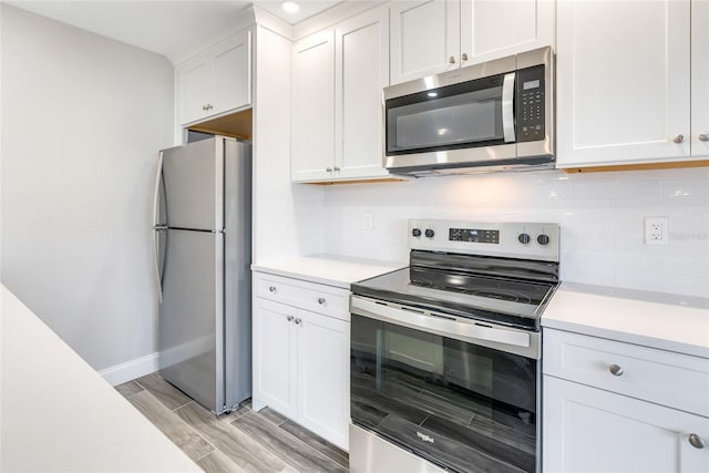 kitchen with backsplash, appliances with stainless steel finishes, and white cabinets