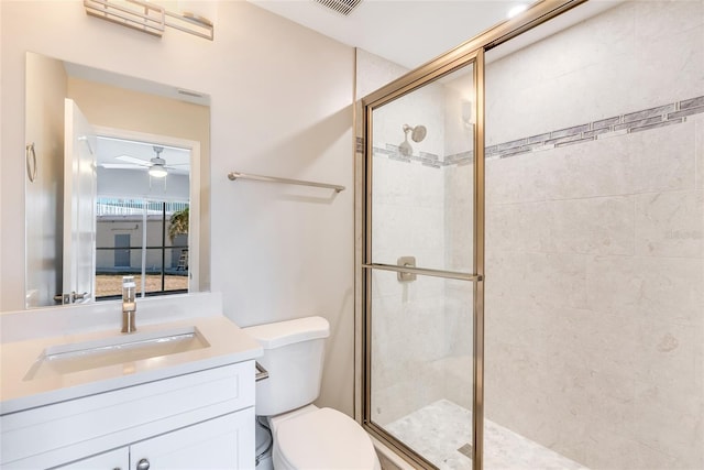 bathroom featuring toilet, vanity, ceiling fan, and walk in shower