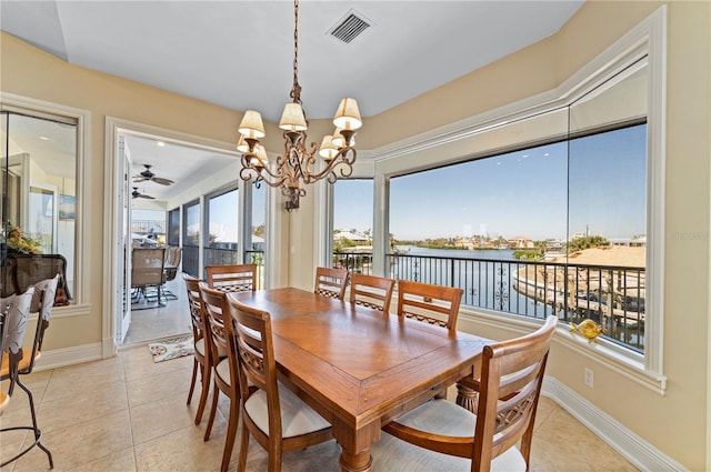 tiled dining room with a water view and an inviting chandelier