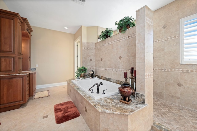 bathroom with tiled bath and tile patterned floors