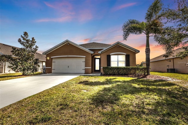 single story home featuring a garage and a lawn