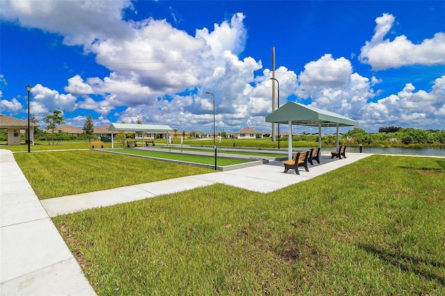 view of home's community featuring a lawn and a water view