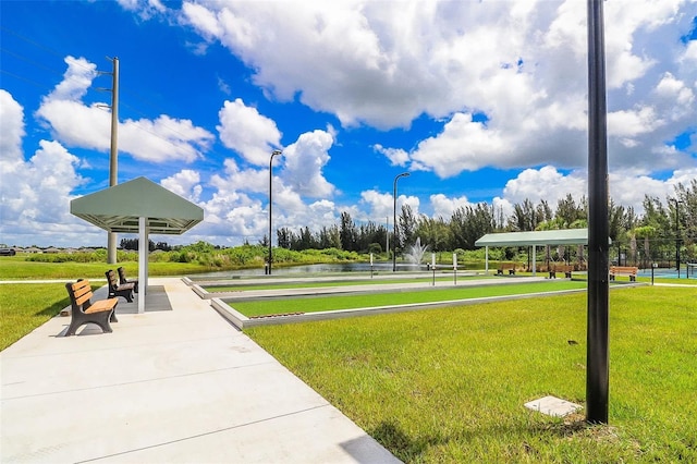 surrounding community featuring a water view and a lawn