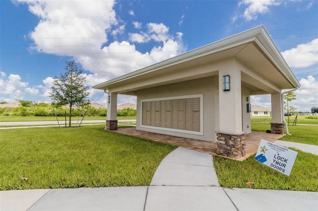 view of home's community featuring a yard and mail boxes