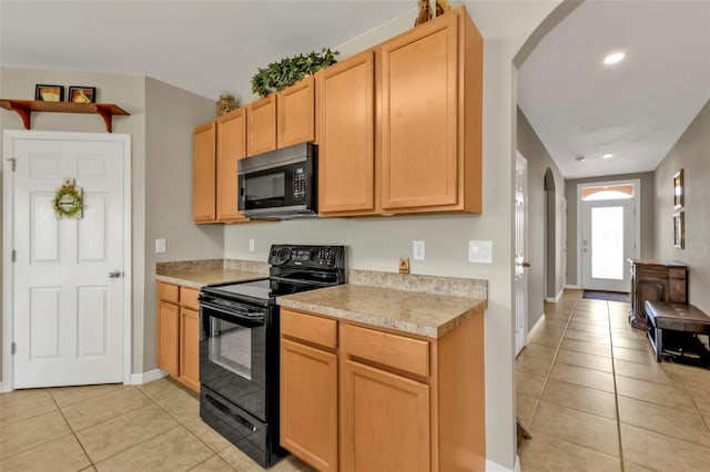 kitchen featuring light brown cabinetry, black range with electric stovetop, and light tile patterned floors