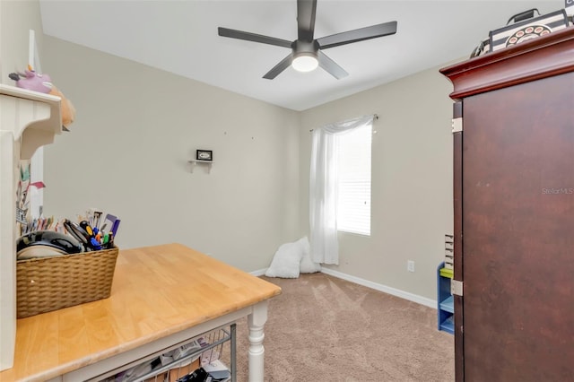 carpeted office space featuring ceiling fan