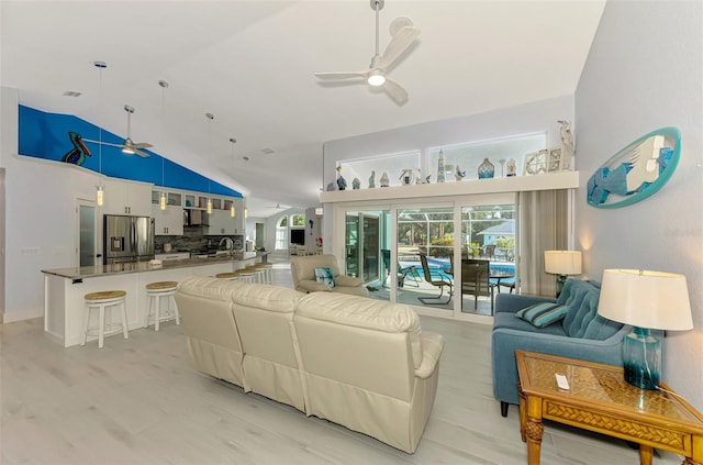 living room with plenty of natural light, high vaulted ceiling, and a ceiling fan