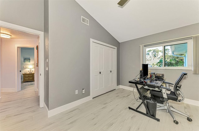 office space with high vaulted ceiling, light wood-style flooring, visible vents, and baseboards