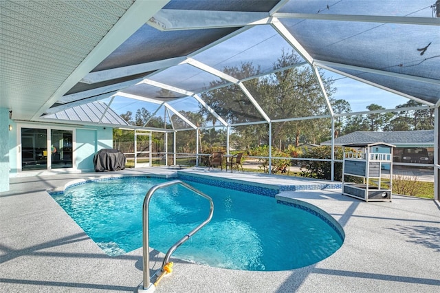 outdoor pool featuring glass enclosure and a patio area