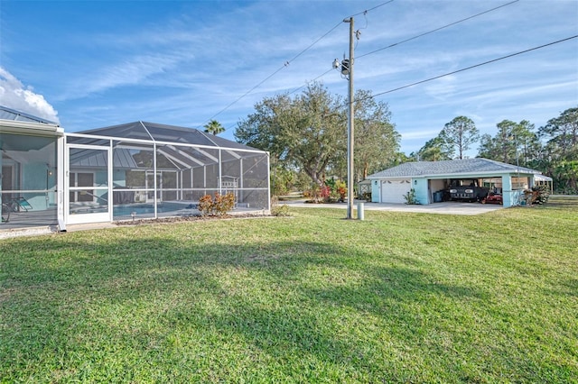 view of yard with a garage and glass enclosure