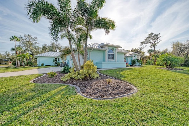 view of front facade with a garage, a front lawn, concrete driveway, and stucco siding