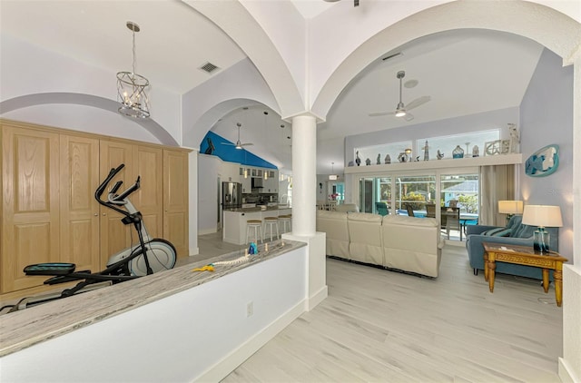 interior space featuring light wood-style floors, lofted ceiling, visible vents, and a notable chandelier