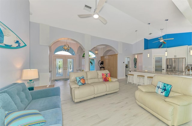 living room featuring high vaulted ceiling, french doors, ceiling fan, and light wood-type flooring