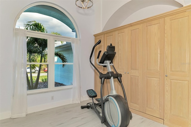 exercise area with light wood finished floors and baseboards