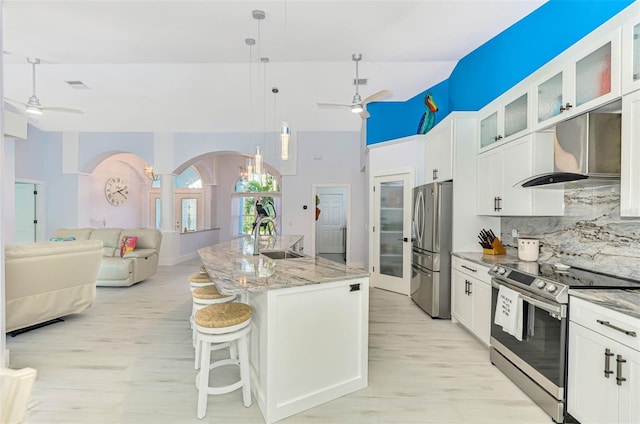 kitchen featuring stainless steel appliances, white cabinetry, sink, and wall chimney exhaust hood