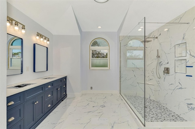 bathroom with tiled shower and vanity