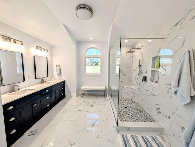 bathroom with marble finish floor, a sink, a marble finish shower, and double vanity