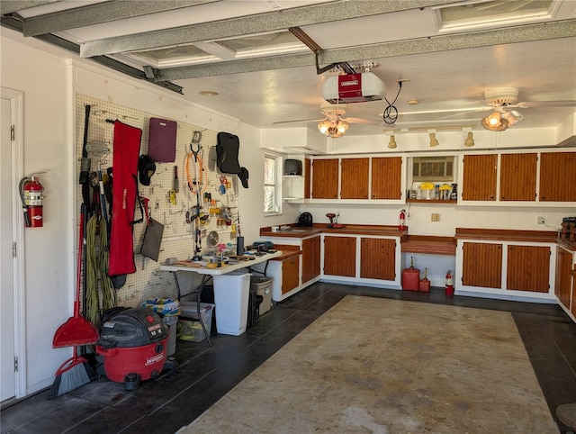 garage with a ceiling fan, a workshop area, and a garage door opener