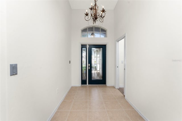 tiled foyer entrance featuring a high ceiling and a notable chandelier