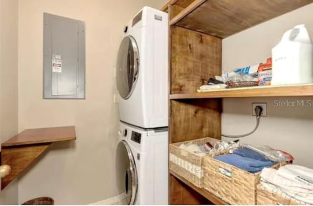 laundry room with stacked washer and dryer and electric panel