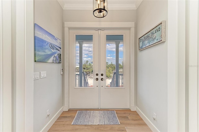 doorway to outside featuring french doors, crown molding, and light wood-type flooring