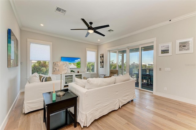 living room with crown molding, ceiling fan, light hardwood / wood-style flooring, and a wealth of natural light