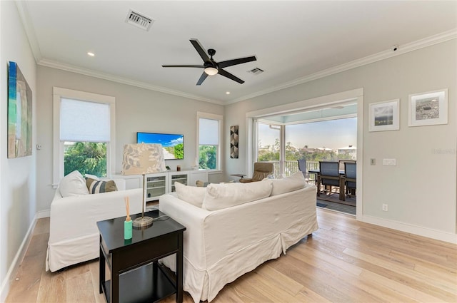 living room featuring ornamental molding, a wealth of natural light, light hardwood / wood-style floors, and ceiling fan