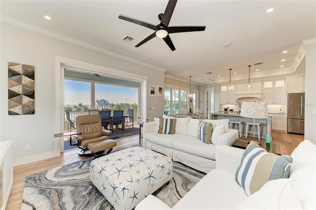 living room featuring ornamental molding and light hardwood / wood-style floors