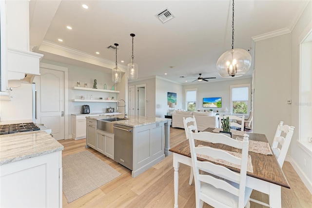 kitchen featuring white cabinetry, a kitchen island with sink, stainless steel dishwasher, and decorative light fixtures