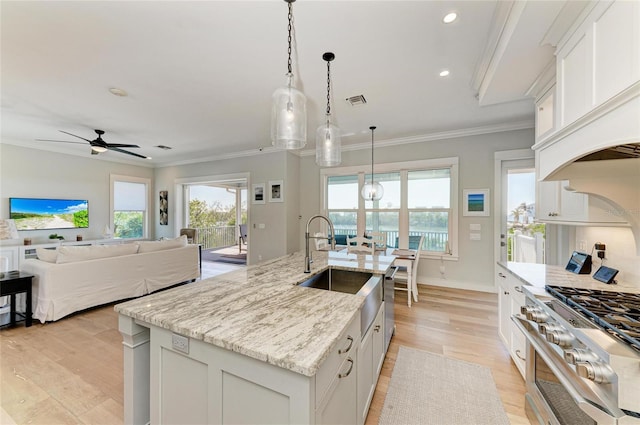 kitchen with pendant lighting, white cabinetry, and a kitchen island with sink