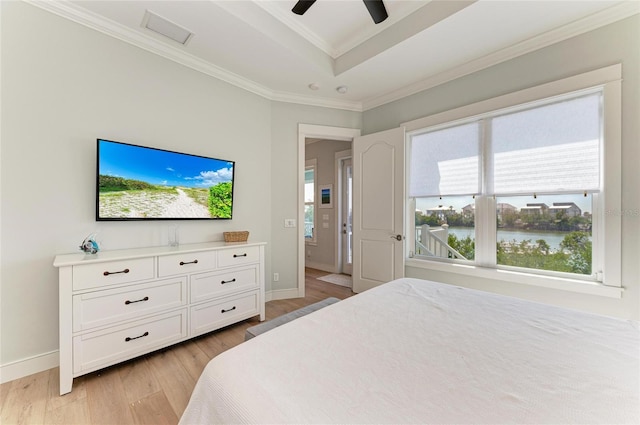 bedroom with crown molding, ceiling fan, a tray ceiling, and light hardwood / wood-style flooring