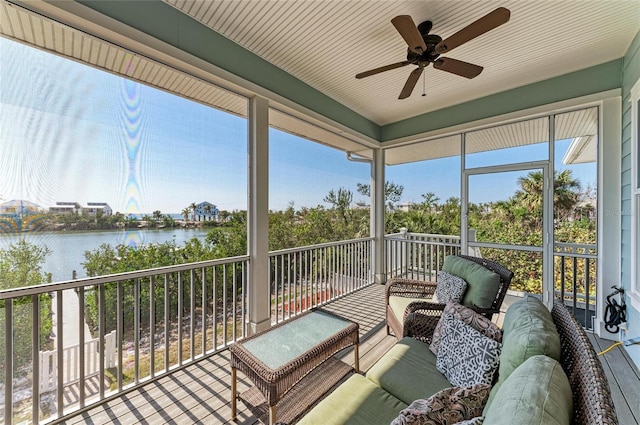 sunroom / solarium featuring ceiling fan and a water view