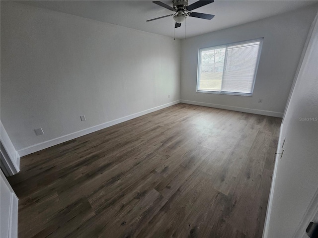 spare room with dark wood-type flooring and ceiling fan