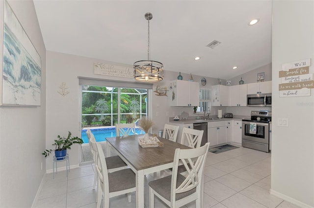 tiled dining area featuring lofted ceiling, sink, and a notable chandelier