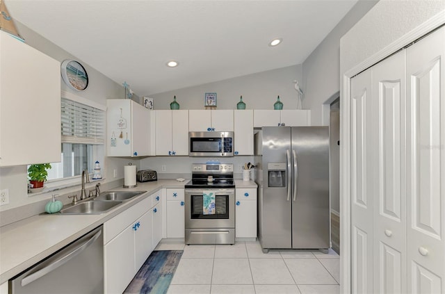 kitchen with light tile patterned floors, appliances with stainless steel finishes, sink, and white cabinets