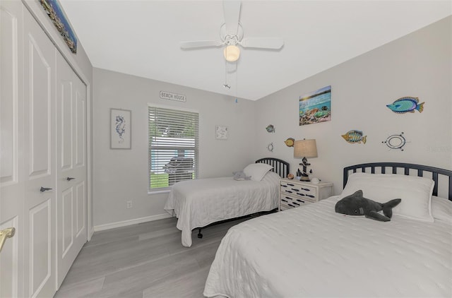 bedroom featuring ceiling fan, a closet, and light hardwood / wood-style flooring