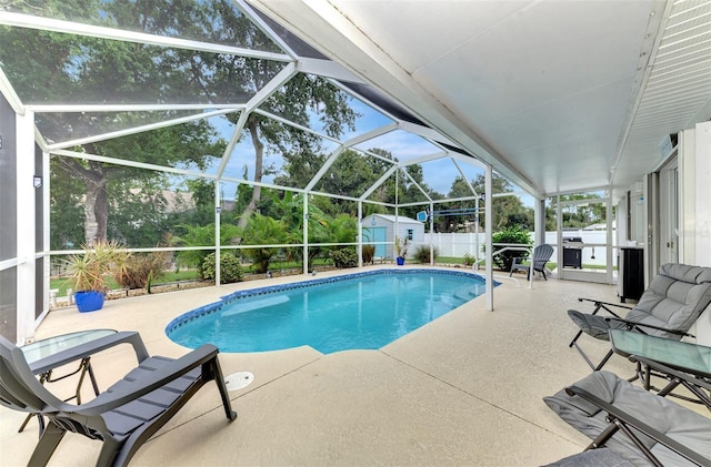 view of swimming pool with a patio area, glass enclosure, and a shed