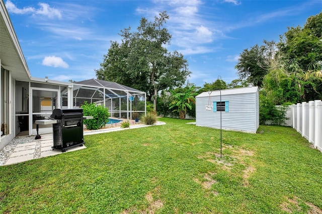 view of yard featuring a pool, a storage unit, and glass enclosure