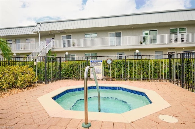 view of swimming pool with a hot tub