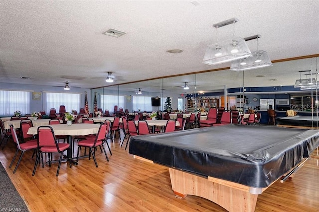 playroom featuring hardwood / wood-style flooring, pool table, and a textured ceiling