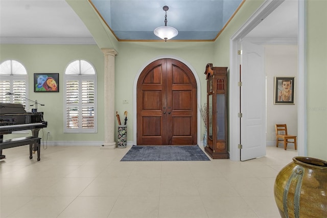 entryway with decorative columns and crown molding