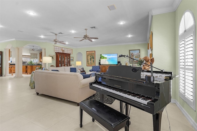 misc room with decorative columns, crown molding, light tile patterned flooring, and ceiling fan